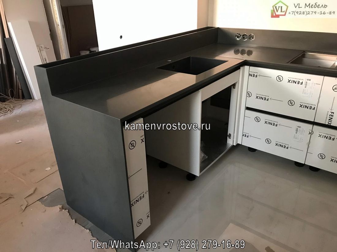 Столешница из искусственного камня серого цвета с интегрированной мойкой и угловой конфигурацией.